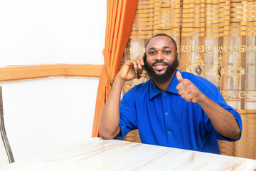 Young African Man Smiling, Answering Phone, Thumbs Up