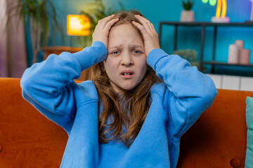 Sad lonely child girl at home looks pensive thinks over life concerns or study test exam fail,...