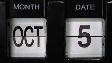 retro flip calendar with a date change from the fourth of October to the fifth of October. daily calendar with a change of days of the month. close up.