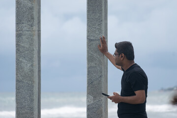 Person watching sea waves with mobile phone in hand. Thinking, suicide, calm, peace, relax, hopeful, mental stress, dilemma, nature, future, savings, family, man, health, focus, anxiety, visionary.