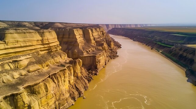 Yellow river, Wide capture of rapid flow yellow river with a steep yellow earth cliffs and magnificent muddy valley landscape