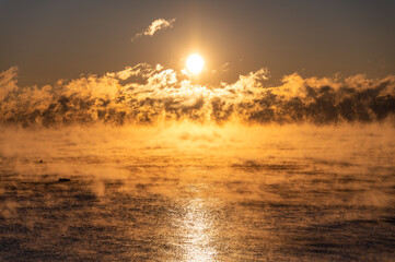 Sun rising over the sea smoke on a frigid morning