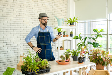 Hipster elderly men take care of the trees, a hobby of urban home gardening after sustainable...