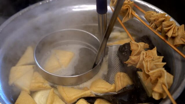 Korean fish cake soup eomuk skewer boiling in local Korea street winter food