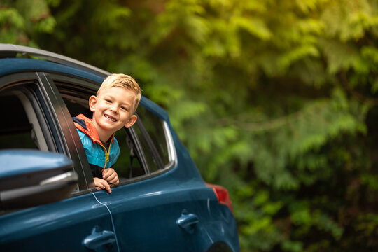 Portrait of happy little boy  in car. Family road trip, summer holiday travel concept.	
