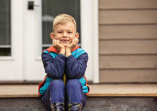 smiling boy sitting on porch 