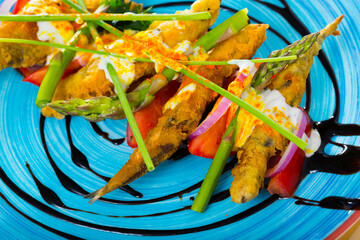 Deliciously fried sardines in batter and creamy-ginger sauce on cushion of sweet tomatoes and...