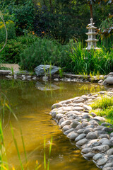 Japanese garden. A pond with a decorative pagoda on the shore.