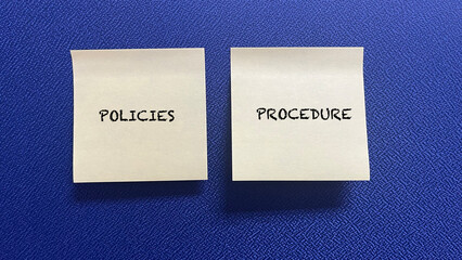 Words Policies And Procedure on sticky note with blue background.