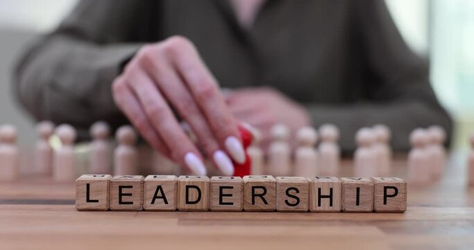 Wooden blocks and the word leadership with red shape standing out among identical white shapes