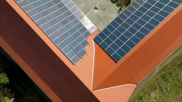 Aerial view of modern solar panels installed on the rooftops of houses, harnessing renewable energy from the sun.