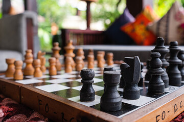 Chess pieces on the board, in a beautiful and cozy hotel interior, with decorative items and...