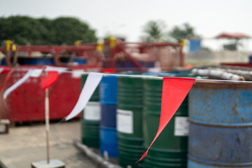 Close-up at the red and white flag line using to barricade chemical barrel the hazardous storage...