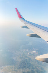 Fototapeta premium View from the airplane window at a beautiful cloudy sky and the airplane wing