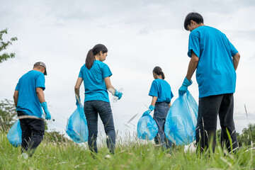 Happy volunteer people group charity with garbage bags cleaning up in park. Corporate social...