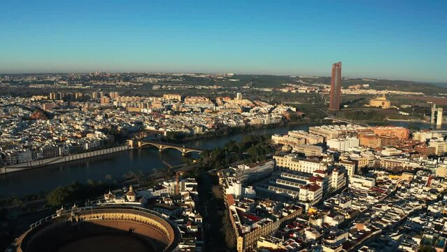 Drone over Bullring of Real Maestranza de Caballeria of Seville With Centro Comercial TORRE SEVILLA In The Background In Seville, Spain. - aerial shot