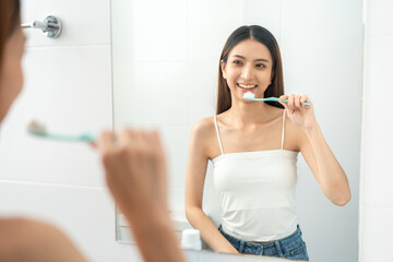 Young smiling asian woman holding brush teeth for the health of teeth in restroom. Take care and good dental health fresh breath