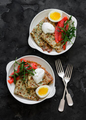 Homemade  breakfast , brunch - potato dill crepes, boiled egg, lightly salted salmon, arugula on a dark background, top view