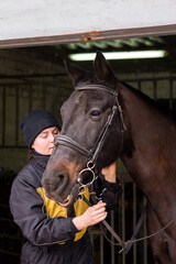Fototapeta premium Affectionate moment between horse and person in stable