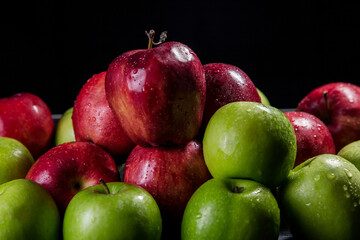 Red and green apples, black background