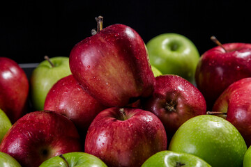 Red and green apples, black background