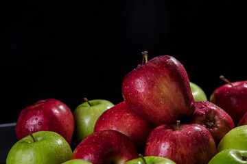 Red and green apples, black background
