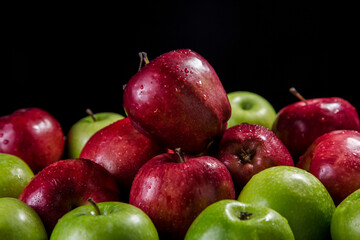 Red and green apples, black background
