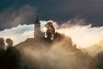 Jamnik, Slovenia - Magical foggy golden summer sunrise at Jamnik St.Primoz church.