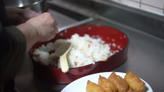 おいなりさんを作る女性