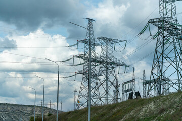 High voltage towers with sky background. Power line support with wires for electricity transmission. High voltage grid tower with wire cable at distribution station. Energy industry, energy saving