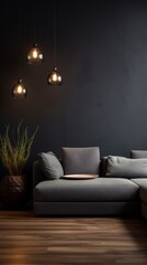 A dark living room with a gray sofa and a plant