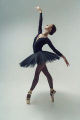 ballerina in a black tutu shows elements of ballet dance in motion