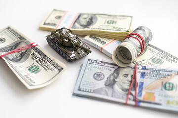 Fototapeta premium Toy tank on US hundred dollar bills banknotes close up. The concept of war costs, military spending and economic crisis