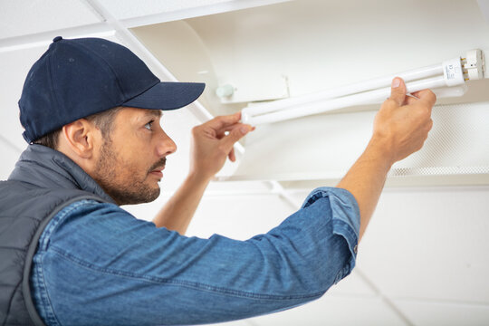 male contractor changing a fluorescent bulb
