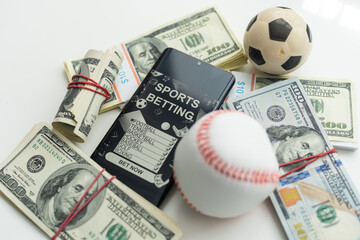 Smartphone with gambling mobile application and soccer ball with money close-up. Sport and betting concept - obrazy, fototapety, plakaty