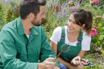 man and woman gardeners at work - obrazy, fototapety, plakaty