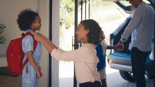 Family at home with parents getting children ready to leave house and go to school
