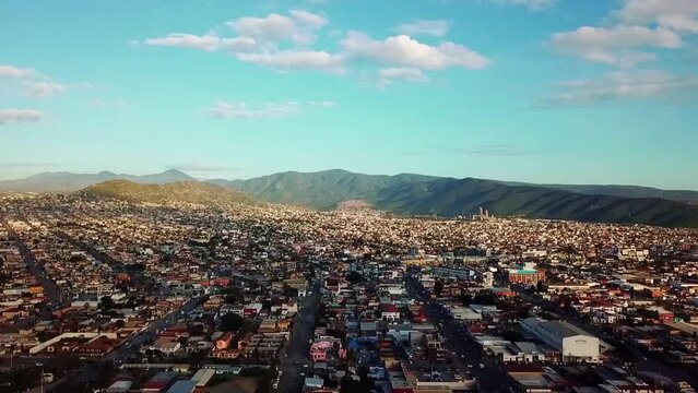 Flying over the city in ensenada town, blue skies, horizon, sunny on a beautiful day in Mexico