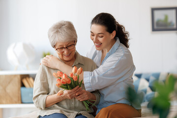woman and her mother with flowers tulips - 775609648