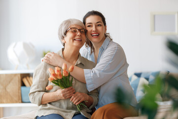 woman and her mother with flowers tulips - 775609659