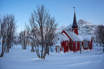 The parish church in Flakstad in winter covered with snow, a red wooden chapel from 1870, near Ramberg Lofoten, Norway
