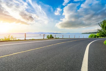 Kussenhoes Asphalt road and lake with sky clouds at sunset © ABCDstock