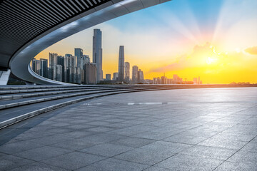 Empty square floor and bridge with modern city buildings at sunset in Guangzhou