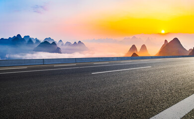 Asphalt highway road and beautiful mountains with sky clouds at sunrise