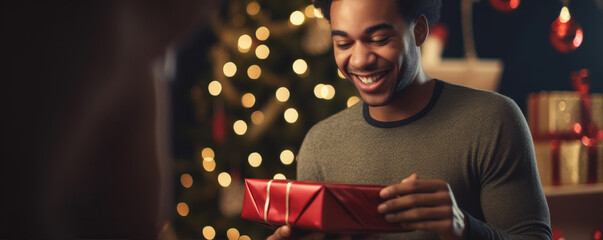 Happy and surprised man with christmas gift in amazing christmas background. Christmas time concept.