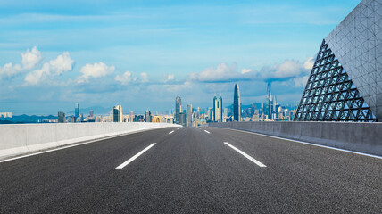 Straight asphalt highway road and glass wall with city skyline in Shenzhen. panoramic view. - obrazy, fototapety, plakaty