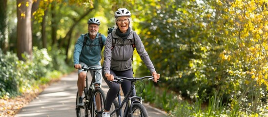 A happy senior couple ride bicycles in an urban park, enjoy the fresh air and nature in spring.