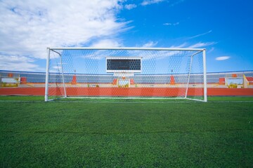 STADIUM - Football field with goal and tablo on blue sky - obrazy, fototapety, plakaty