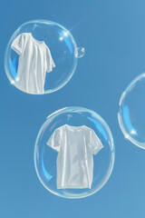 White T-Shirts Floating in Soap Bubbles Against a Clear Blue Sky