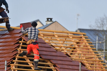 ouvrier couvreur sur un toit d'habitation  - 775623011
